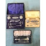 Three cased hallmarked silver manicure sets, one with repoussé decoration - Birmingham 1908, and two