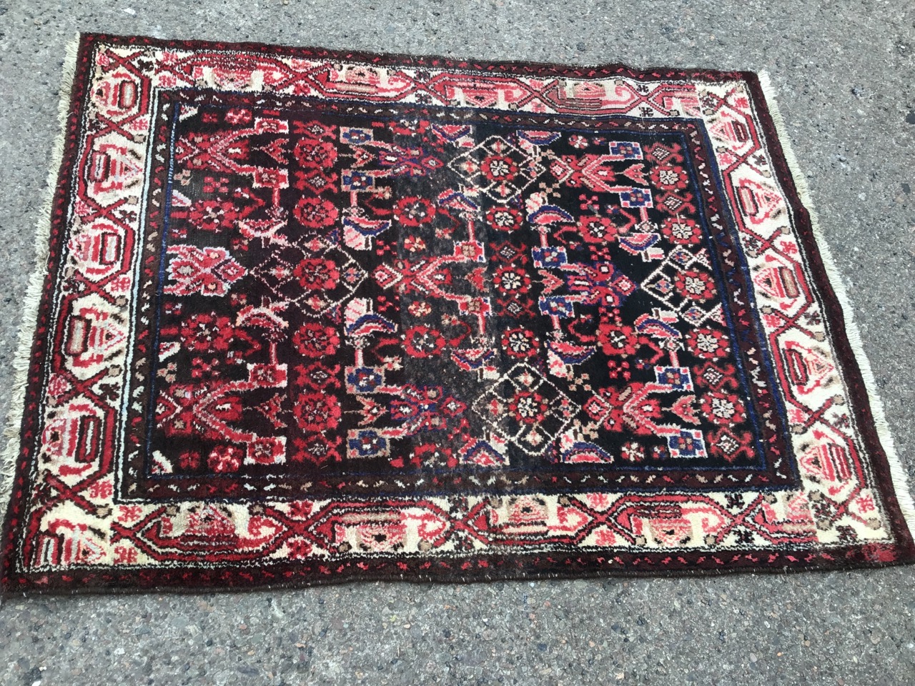 A Turkish rug woven with geometric style bands to brown field, the ivory frieze with linked altar