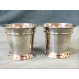 A pair of hallmarked tapering silver beakers with flared rims raised on moulded bases - London,