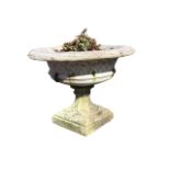 A large Victorian campana garden urn with overhanging leaf moulded rim above a strap-woven body