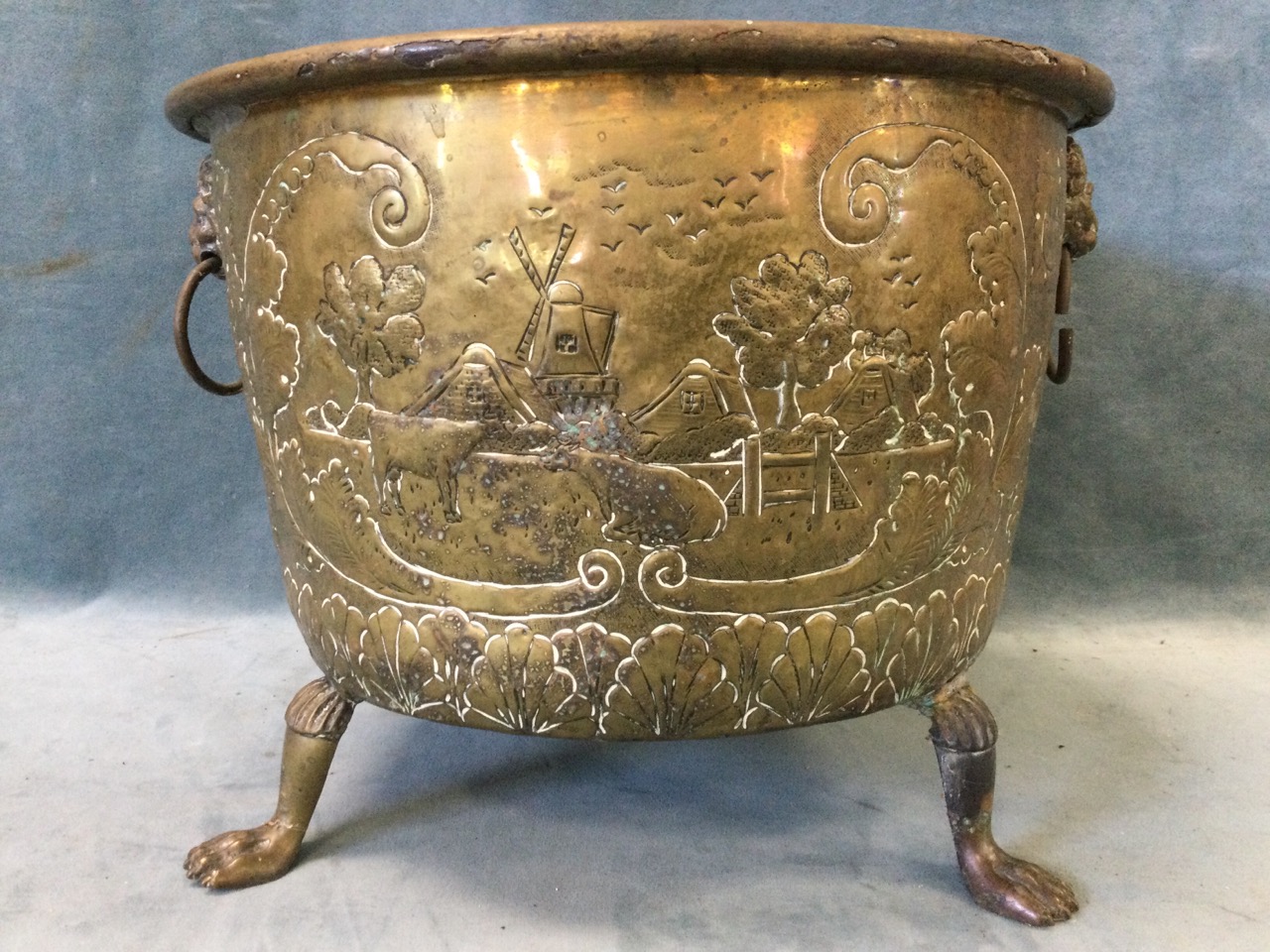 A nineteenth century embossed brass log bin raised on paw feet, the sides with lionmask ring handles - Image 2 of 3