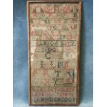 A nineteenth century embroidered sampler with alphabet and numbers sewn in coloured wools -