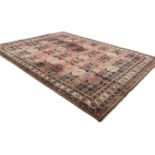 A machine woven Turkoman style carpet, the striped field with alternating rows of gul and