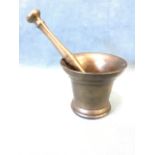 An ancient bronze mortar & pestle, the heavy flared vessel with ring decoration, the grinding tool