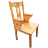 An arts & crafts style oak church armchair, the back with square chamfered columns framing pierced