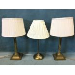 A pair of brass tablelamps with pleated shades on fluted corinthian columns, with square bases;