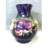 An ovoid Moorcroft vase with tube lined decoration of poppies and leaves on blue brushwork