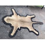 An antique cheetah skin rug, the skin laid on felt ground. (78in)