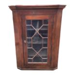 A nineteenth century mahogany corner cabinet with moulded cornice above an astragal glazed door