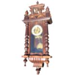A late Victorian walnut Vienna wallclock with architectural style pediment above an arched glazed