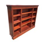 A mahogany reproduction open bookcase with dentil cornice above two narrow compartments centering