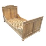 A Victorian European pine bateau type bed with panelled headboard & tailboard and shaped side