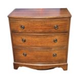A Georgian style bowfronted mahogany chest of drawers, the top with reeded edge above three