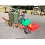 Miscellaneous fuel and oil cans including two jerry cans, an Eversure petrol can, pump oil cans, a