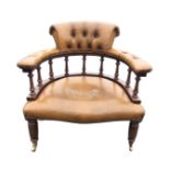 A leather button upholstered mahogany captains chair with brass studding, the horseshoe shaped