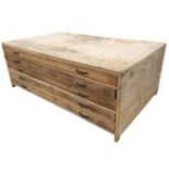 A pine plan chest with five long shallow drawers mounted with steel strap handles, raised on short