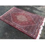 A Kashan style rug woven with multi-floral field centering on a hexagonal medallion with pendants,