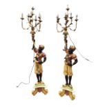 A pair of painted gilt blackamoor torcheres, each with seven scrolling foliate gilt metal arms