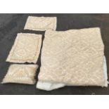 An American quilted cover woven with yellow and cream scrolled foliage, with matching pillowcases;