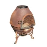 A bulbous chimenea with mesh hinged door enclosing a burning chamber, raised on scrolled feet. (