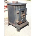 A Coabrookdale cast iron stove with glazed door and fluted burning chamber above a platform with