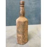 An hexagonal lead bottle shaped weight embossed Booths Distilleries with panel "Herein are the