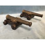 A pair of naval cannon models, the tapering brass chases with two reinforces on stepped oak