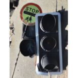 A red, amber & green traffic light with circular lenses in case; a lollipop persons stop sign; and a