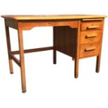 A mid-century oak desk with a slide above three drawers mounted with bar handles, beside a