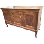 A rectangular Edwardian mahogany sideboard with raised panels to drawers and cupboards, the centre