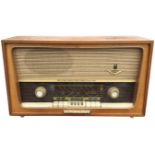 A 1950s Grundig valve radio in teak case with glass dial and bakelite control panel with knobs. (