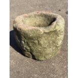 An ancient circular rough-hewn sandstone quern mortar. (16.5 in x 16.5in x 12.5in)