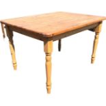 A contemporary pine kitchen table, the rectangular top on a moulded frame with tapering turned legs.