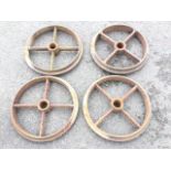 A set of four cast iron wheels, each with 2.25in hubs and four chamfered spokes to shaped rims. (