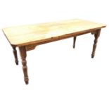 A Victorian pine kitchen table with rectangular rounded top above shaped aprons, raised on turned