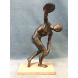 A cast bronzed statue of a classical style nude male discus thrower, mounted on a marble plinth. (