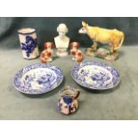 A collection of ceramics including a continental glazed terracotta cow, a German porcelain bust of