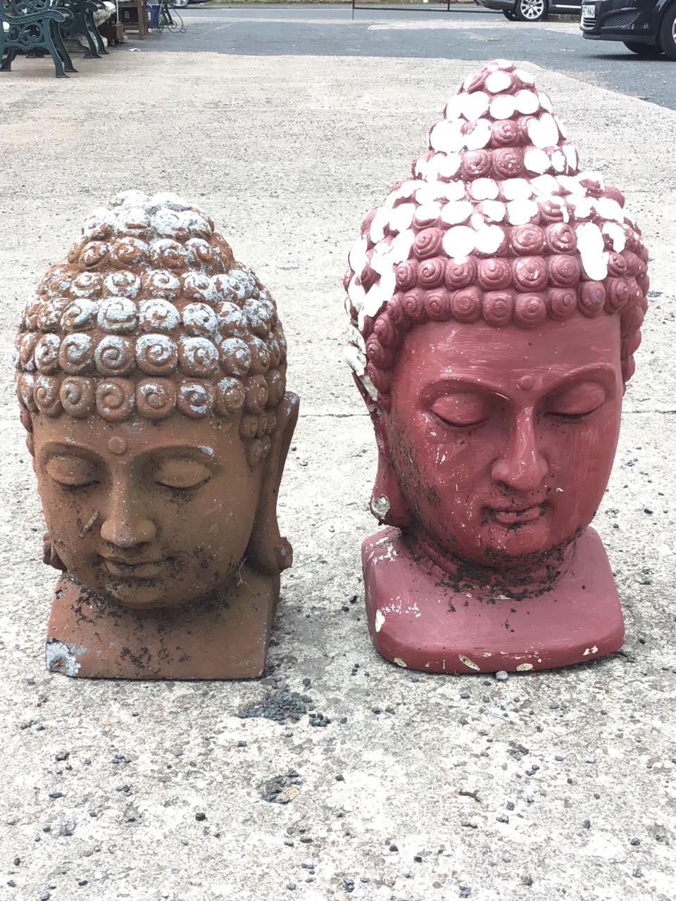 A painted composition buddha head - 19in; and another similar - 15.5in. (2)