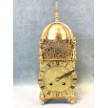 A lantern clock dated 1938 with French movement and roman chapter ring framed by turned cornerposts,