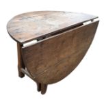 An antique oak gateleg coffee table, the circular top with a single flap supported by a swing leg,
