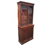 A Victorian mahogany bookcase cabinet, the moulded cornice above a pair of glazed doors, the