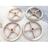 A set of four cast iron wheels, each with 2.25in hubs and four chamfered spokes to shaped rims. (