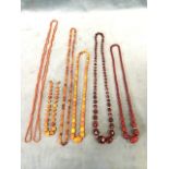 Six amber, glass & coral bead necklaces, some individually knotted, some graduated beads,