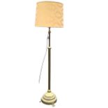 A telescopic brass standard lamp with ribbed column on circular weighted base above floral