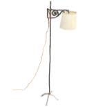 A wrought iron art nouveau standard lamp with adjustable scrolled bracket on square column with