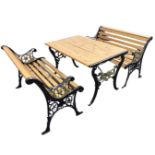 A cast iron garden table and bench set, with slatted seats andf tabletop on pierced foliate scrolled