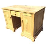 A Victorian pine kneehole desk, the rectangular top above a central drawer, and two pedestal