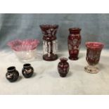 A collection of Victorian ruby glass - a lustre with cut prisms, a vase with rose motifs, a small