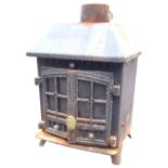 A cast iron stove with chamfered canopy above rectangular burning chamber and pair of glazed doors