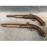A pair of replica flintlock pistols with inlaid gilt scrolled decoration to hardwood stocks, the